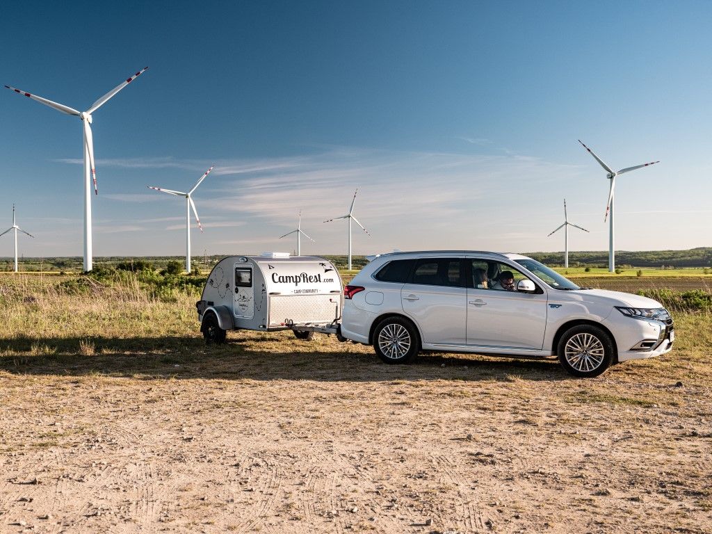 Mitsubishi Outlander z przyczepą na tle wiatraków